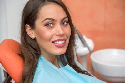 woman smiling after clear teeth aligners helped straighten her smile