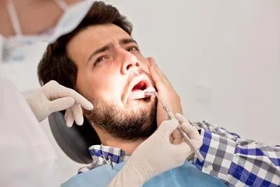man visiting the dentist due to tooth pain
