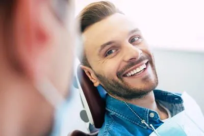 patient smiling after getting a gingivectomy to clear up his smile